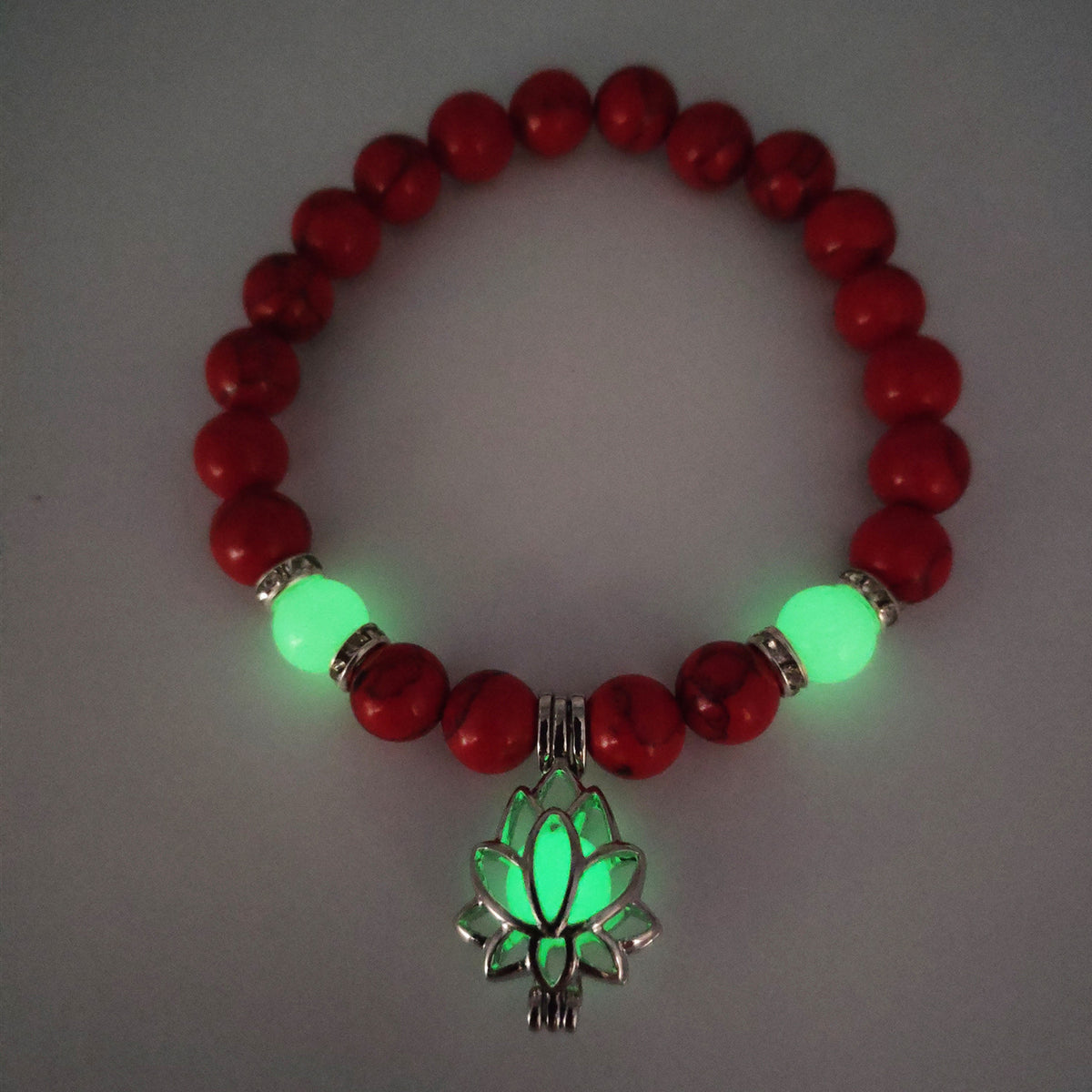 Glow in the dark lotus bracelet red stone beads with a green glow view, with 8 mm real-stone beads, elastic fit, a silver-color lotus, and light-charged accents for low-light wear.