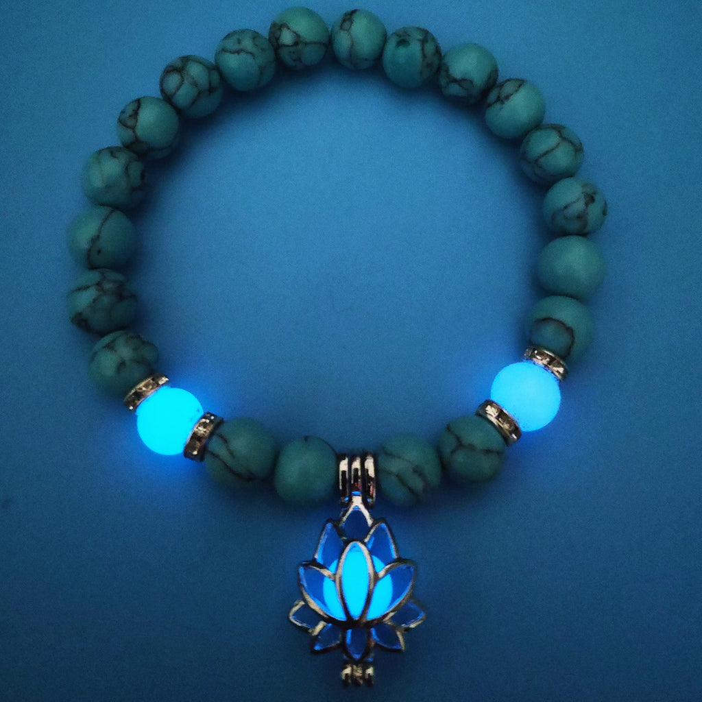 Glow in the dark lotus bracelet blue-green beads with a blue glow view, with 8 mm real-stone beads, elastic fit, a silver-color lotus, and light-charged accents for low-light wear.