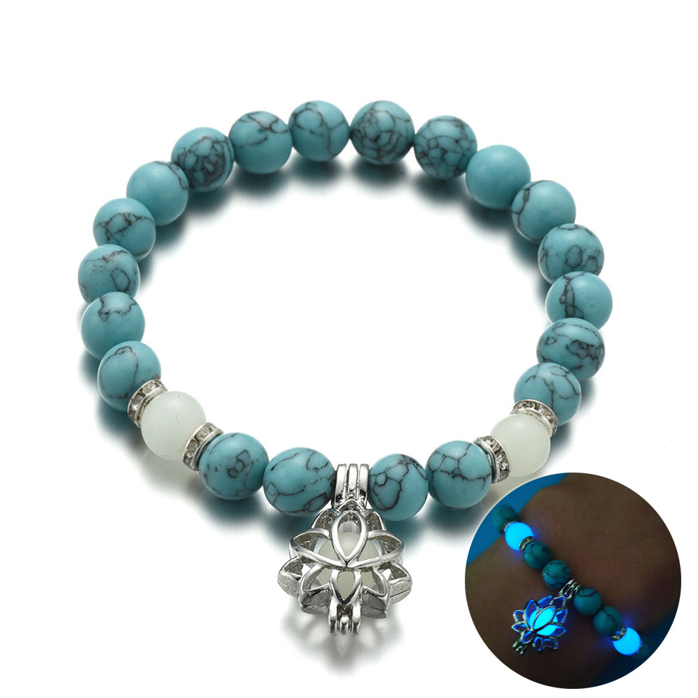 Glow in the dark lotus bracelet blue-green stone hero view and glow inset, with 8 mm real-stone beads, elastic fit, a silver-color lotus, and light-charged accents for daily style.