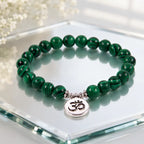 Green tigereye natural stone bracelet featuring glossy beads and silver Om charm with elegant reflection