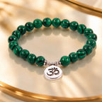 Green tigereye beaded bracelet with striped natural gemstone beads and silver Om charm on luxury display