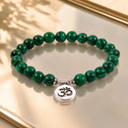 Green tigereye beaded bracelet with polished gemstone pattern and Om symbol for spiritual style