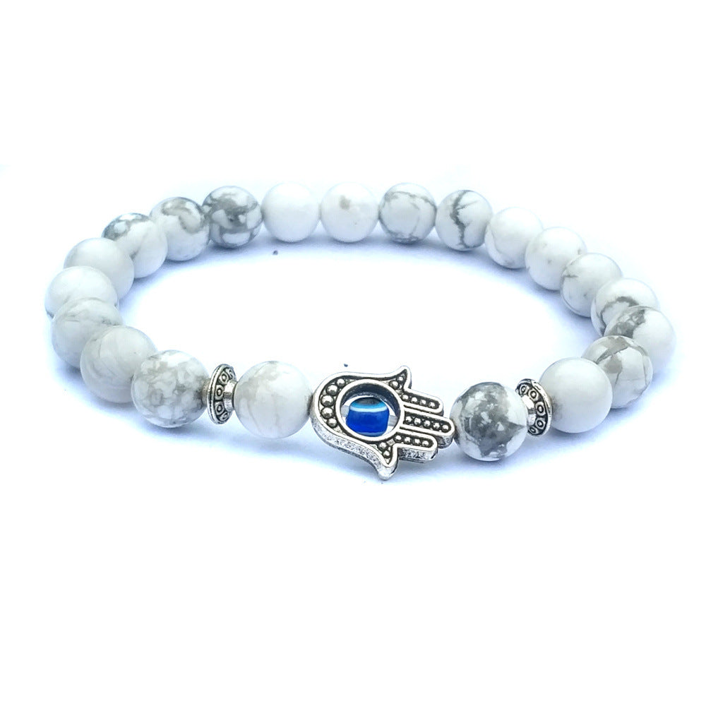 White Hamsa evil eye bracelet with marbled round natural-stone beads, silver-tone alloy spacers and a blue-eye hand centerpiece, photographed on clean, bright white background set.