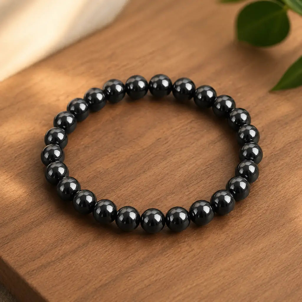 Hematite bracelet shiny black beads on wooden surface showcasing magnetic stone jewelry for calming energy and everyday wear