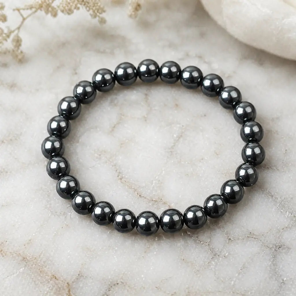Hematite bracelet polished black bead jewelry on marble surface for balance energy protection and stylish daily wear