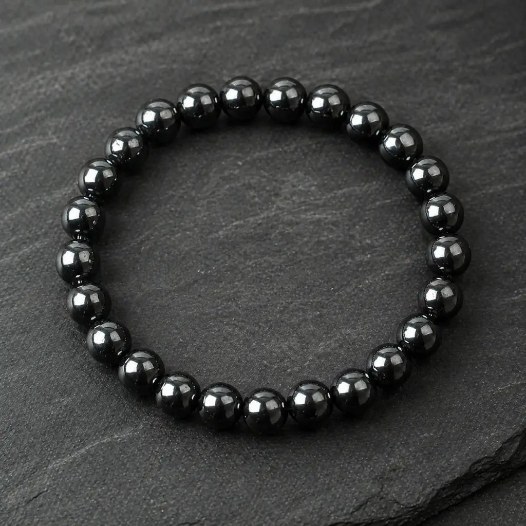 Hematite bracelet black bead jewelry on slate surface highlighting magnetic stone for strength focus energy and modern fashion use