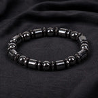 Hematite bracelet with polished black beads and sleek gemstone accents on dark fabric for modern style appeal