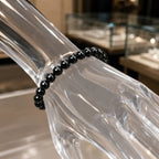 Hematite bracelet worn on a wrist with polished black crystal beads creating elegant energy jewelry appeal