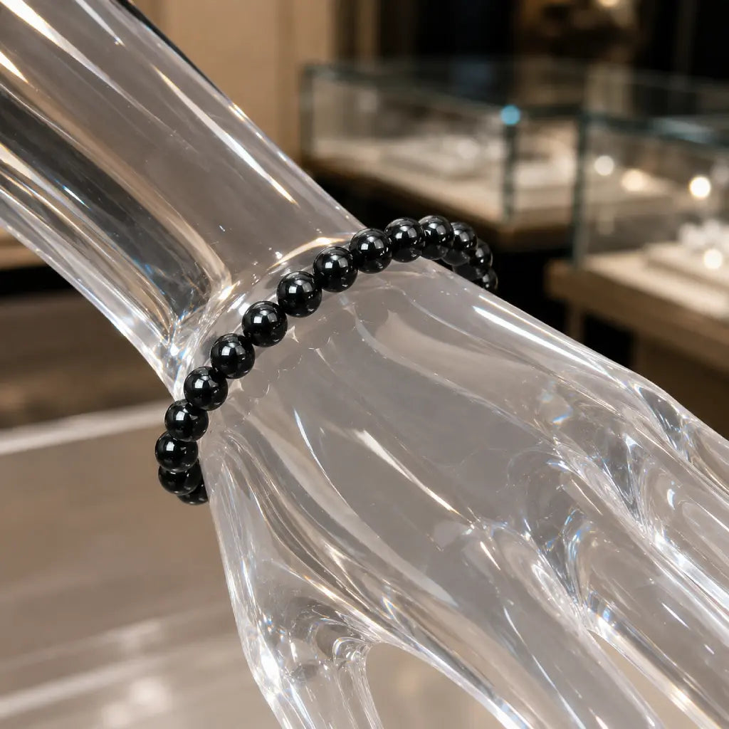 Hematite bracelet worn on a wrist with polished black crystal beads creating elegant energy jewelry appeal