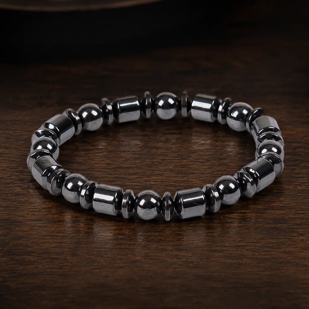 Hematite bracelet with polished black gemstone beads on wood surface creating versatile luxury appeal