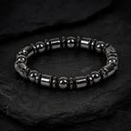 Hematite bracelet featuring glossy black gemstone beads on textured stone for refined everyday fashion wear