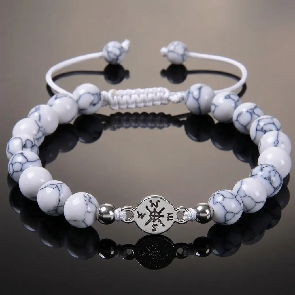 Howlite bracelet featuring white marbled gemstone beads on reflective black surface for luxury wellness wear