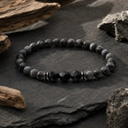 Labradorite and Obsidian bracelet displayed on natural slate with grounding gemstone energy aesthetic style.