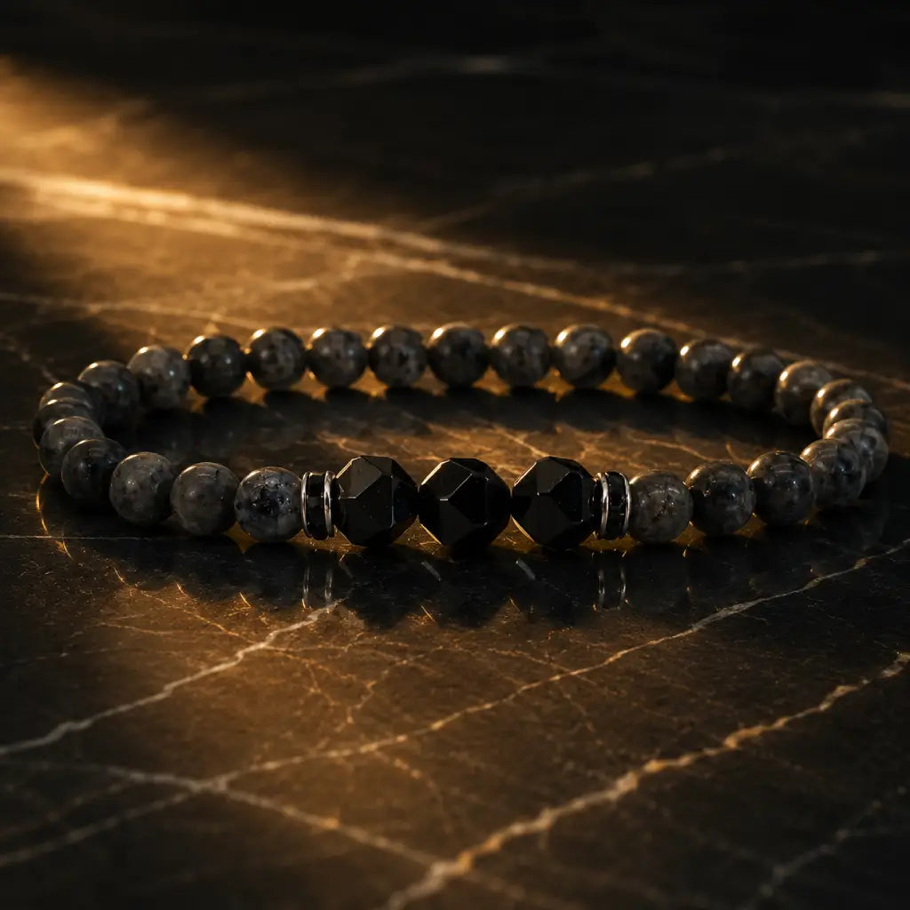 Labradorite and Obsidian bracelet with faceted black stones on dark marble for bold luxury accessory looks.