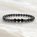 Labradorite and Obsidian bracelet with dark crystal beads on polished marble creating refined minimalist appeal.