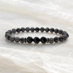 Labradorite and Obsidian bracelet with dark crystal beads on polished marble creating refined minimalist appeal.