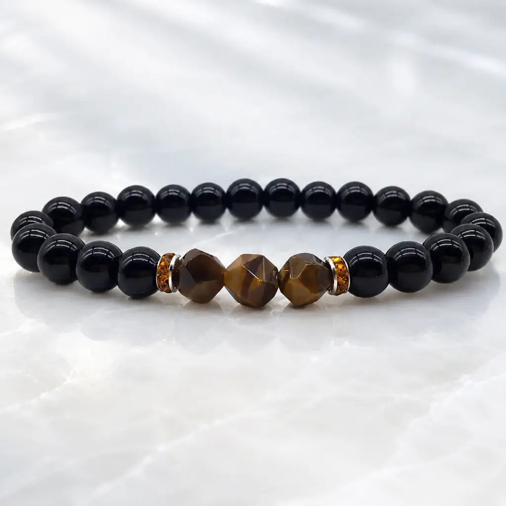 Labradorite and tiger eye bracelet on bright marble with faceted gemstones for healing energy and balance