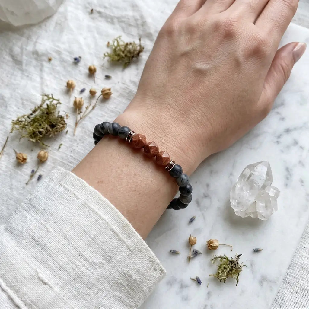 Labradorite crystal bracelet styled with clear quartz and dried herbs for spiritual protection and mindfulness
