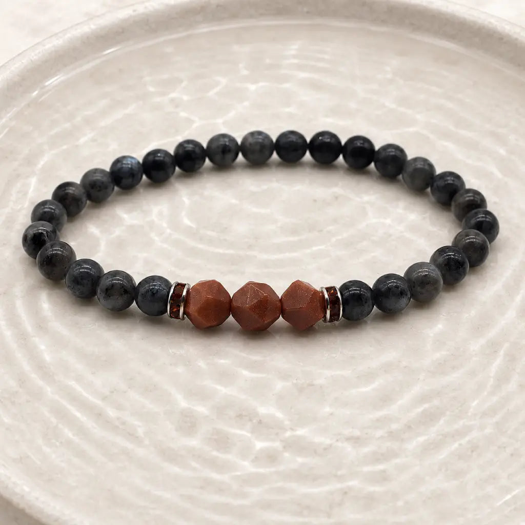 Labradorite crystal bracelet on textured neutral surface featuring grounding gemstone beads for spiritual wellness