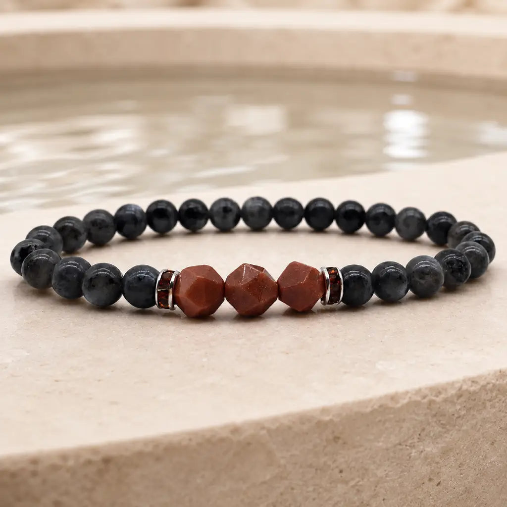 Labradorite crystal bracelet photographed near tranquil water for grounding energy healing and mindful relaxation