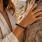 Labradorite dzi bracelet worn near natural rock with black gemstone beads for grounding outdoor wellness style