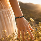 Labradorite dzi bracelet worn outdoors with black gemstone beads and golden light for calming energy balance