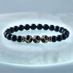 Labradorite dzi bracelet product photo with matte black beads and polished Dzi stones on white background