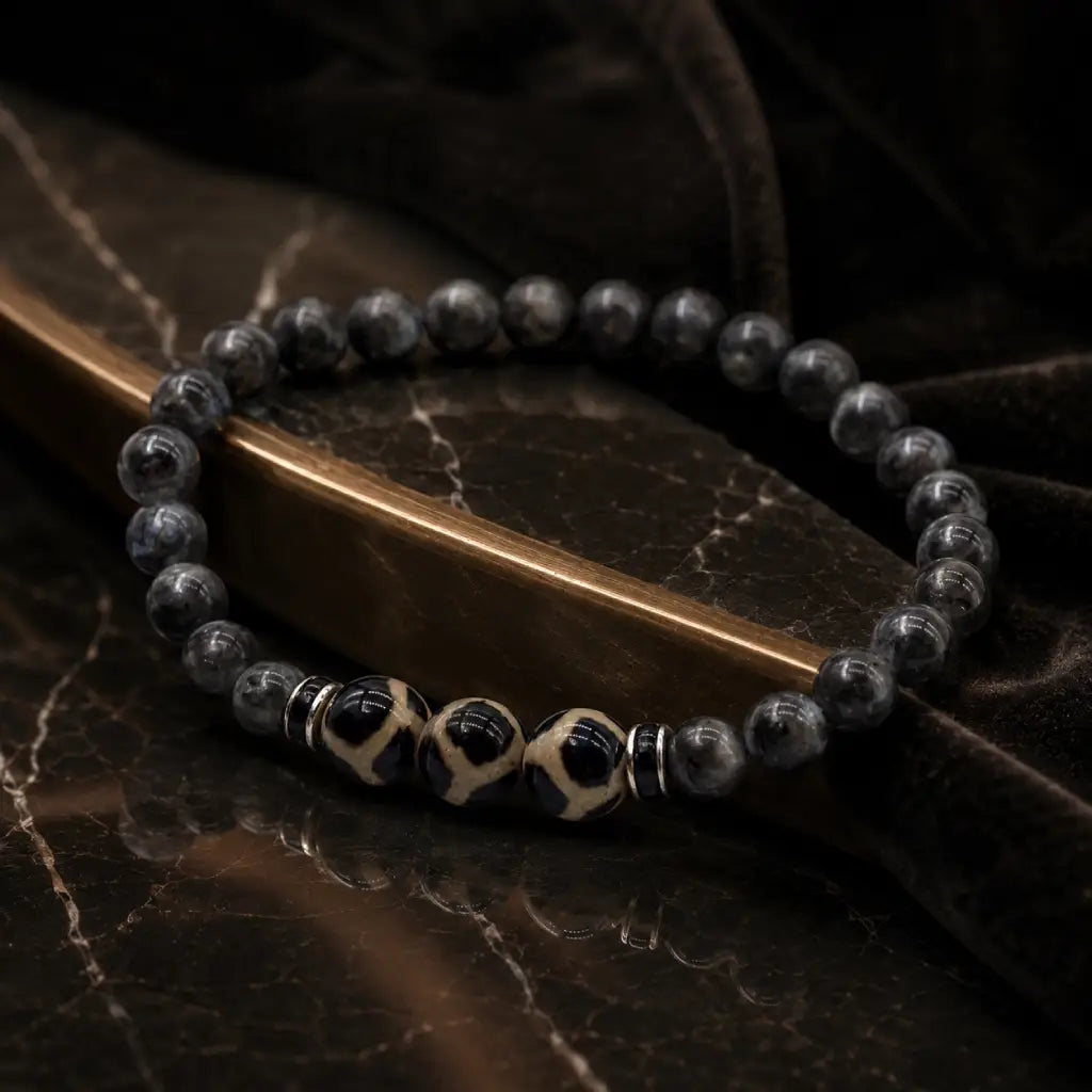 Labradorite dzi bracelet displayed on dark marble with polished black beads for premium healing jewelry style