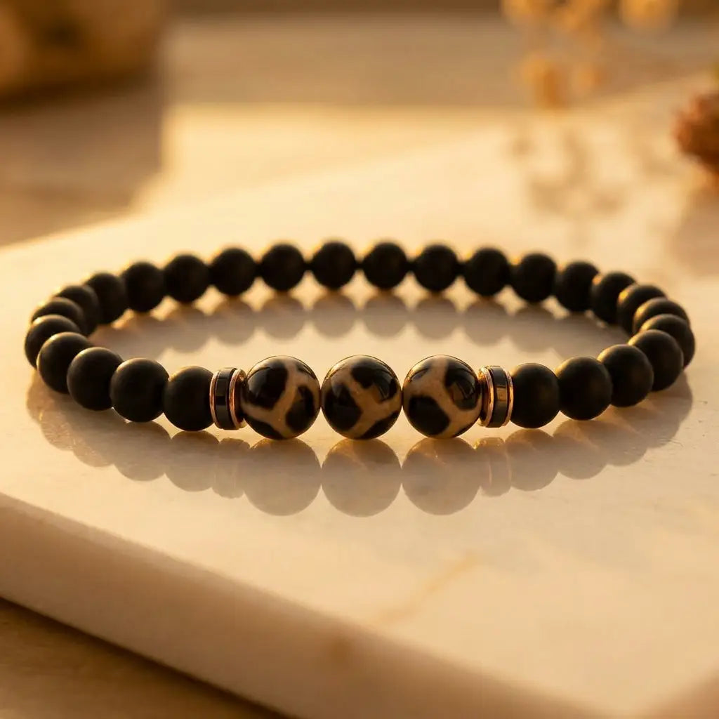 Labradorite dzi bracelet with matte black beads and glowing Dzi stones at sunset for grounding spiritual style