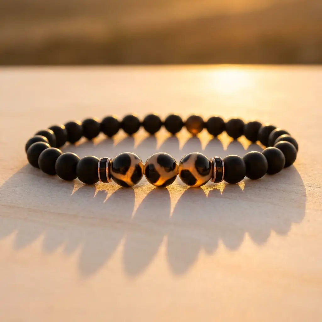 Labradorite dzi bracelet with matte black beads and glowing Dzi stones at sunset for grounding spiritual style