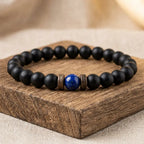 Lapis lazuli and matte black onyx beaded bracelet displayed on dark walnut wood block, premium handcrafted crystal healing gemstone jewelry