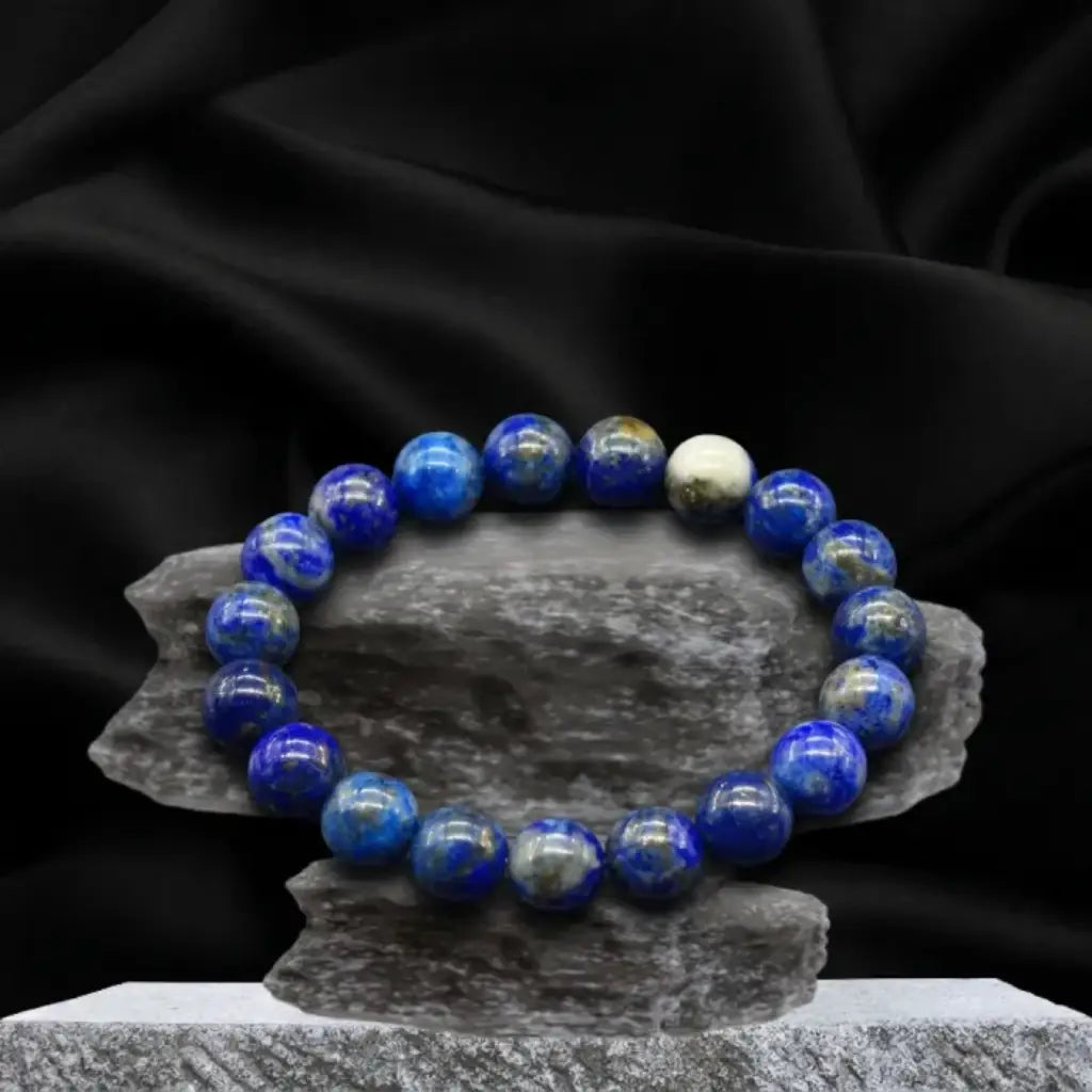 Lapis lazuli bracelet on stone stand with black satin backdrop, premium crystal bead jewelry for bold styling
