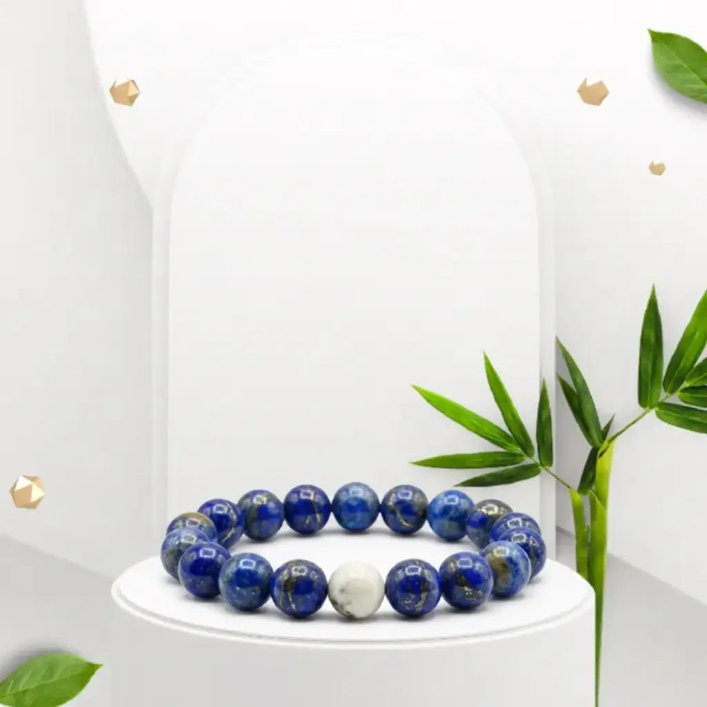 Lapis lazuli bracelet on white pedestal with botanical accents, polished gemstone jewelry for elegant gifting