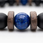 Lapis Lazuli onyx bracelet macro showing a polished blue lapis lazuli bead framed by textured spacers and matte black onyx beads.