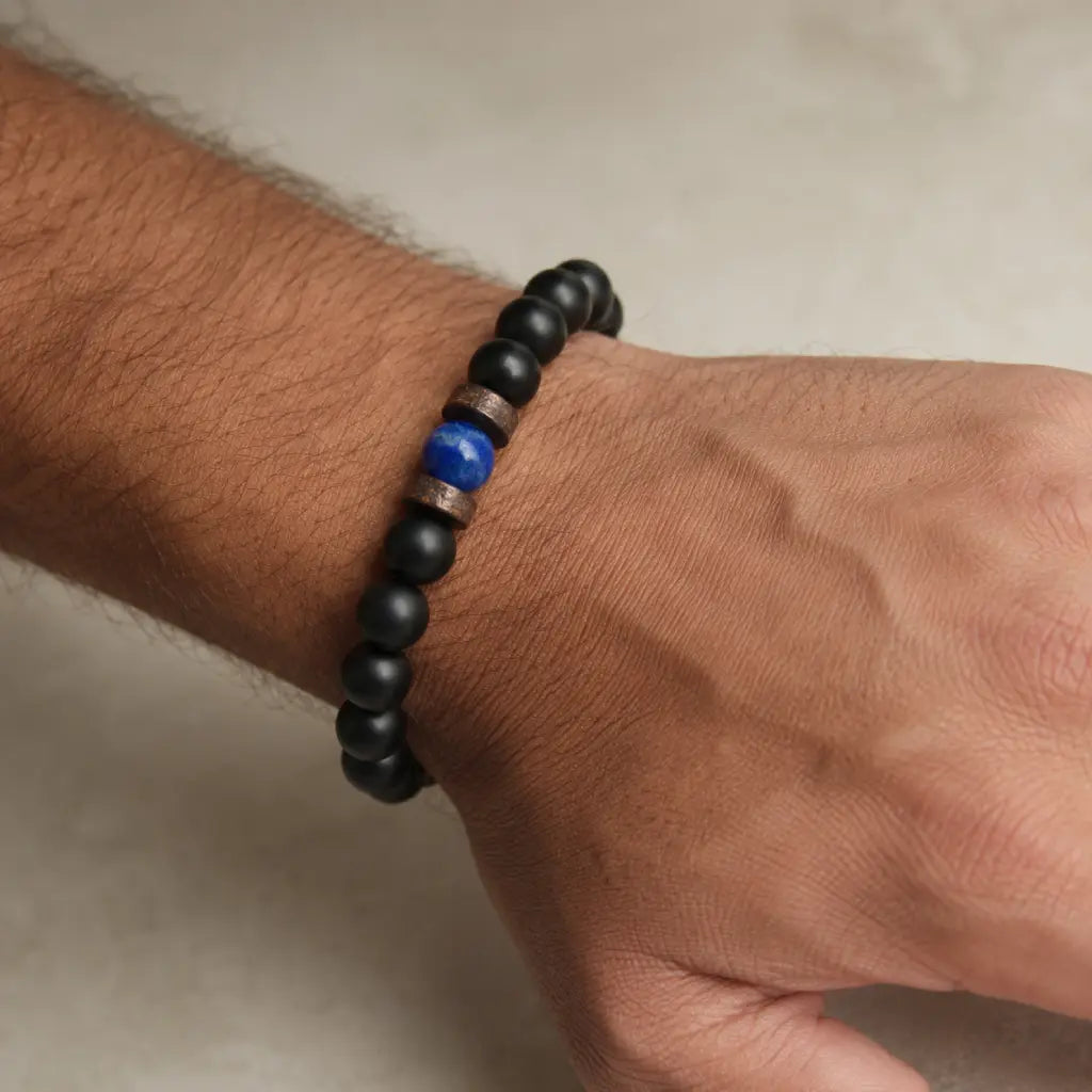 Lapis Lazuli onyx bracelet on a wrist with matte black onyx beads, natural blue lapis lazuli stone, and rustic metal spacer details.