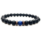Lapis Lazuli onyx bracelet displayed on a white background with matte black onyx beads, blue lapis lazuli center stone, and spacer accents.
