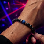 Lapis Lazuli onyx bracelet with matte black onyx beads and vibrant blue lapis lazuli centerpiece, styled for a modern evening look.