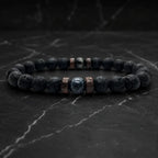 Lava labradorite bracelet displayed on dark marble with volcanic beads and crystal details for grounding energy