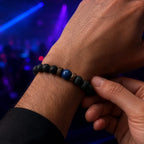 Lava Rock Lapis Lazuli bracelet being adjusted on the wrist featuring authentic lava beads and polished lapis gemstone for comfortable everyday wear.