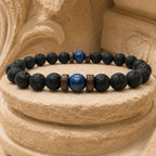 Lava Rock Lapis Lazuli bracelet resting on a stone pedestal with natural lava beads and striking lapis gemstone for timeless men's fashion.