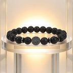 Lava stone bracelet showcased on illuminated stand featuring natural volcanic beads for refined styling.