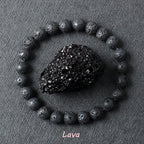 Lava stone bracelet with rough porous dark black volcanic beads surrounding a raw lava rock specimen on dark grey background