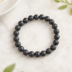 Lava stone bracelet black round bead stretch bracelet on light stone with plant accents, grounding jewelry look