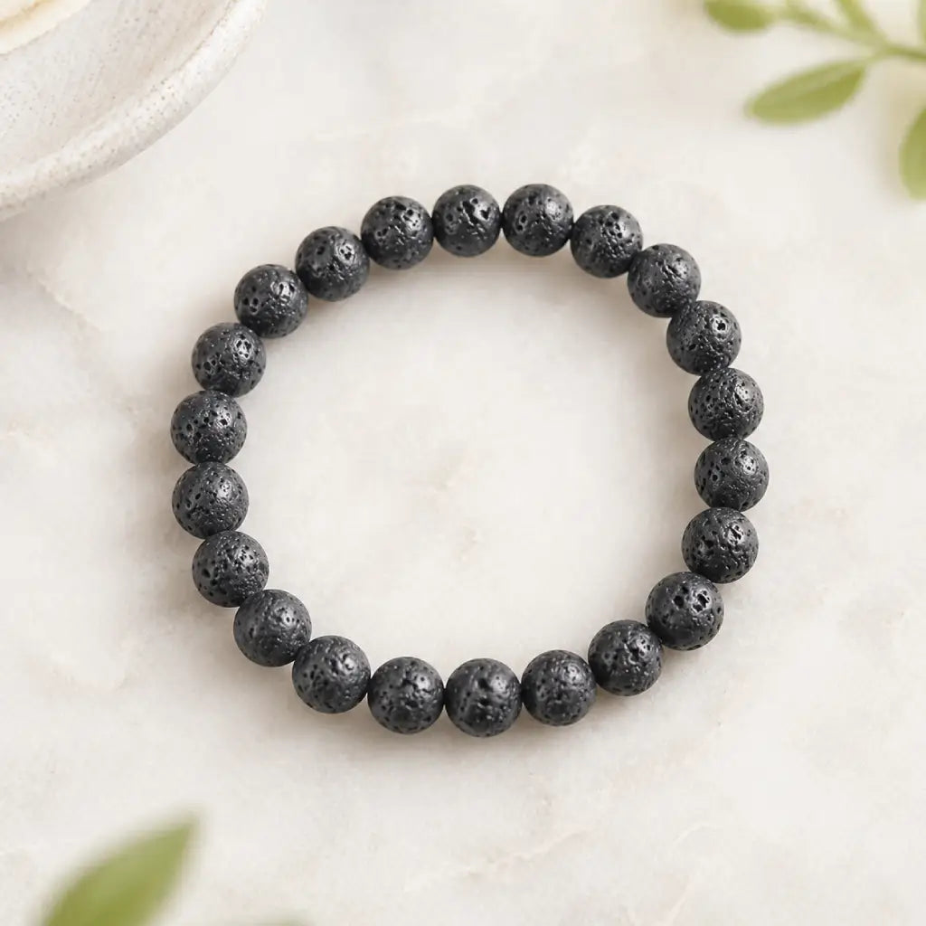 Lava stone bracelet black round bead stretch bracelet on light stone with plant accents, grounding jewelry look