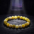 Lemon jade bracelet on textured dark stone with dramatic lighting, premium gemstone jewelry for bold elegant display
