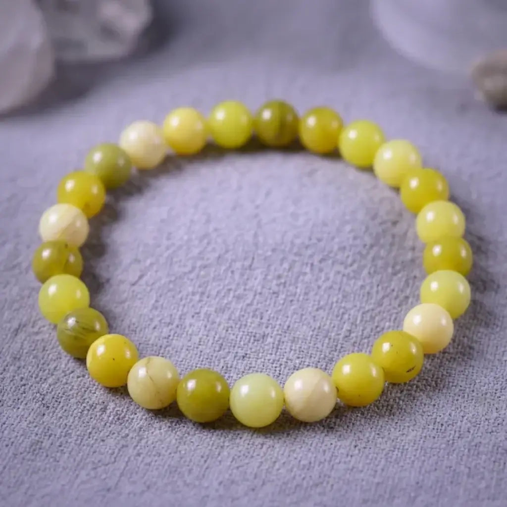 Lemon jade bracelet on textured neutral fabric with polished beads, natural gemstone jewelry for calm minimalist style
