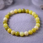 Lemon jade bracelet on textured neutral fabric with polished beads, natural gemstone jewelry for calm minimalist style
