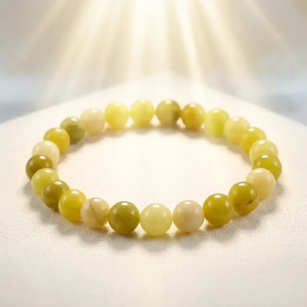 Lemon jade bracelet glowing under soft sunlight with polished beads on fabric, natural gemstone jewelry for radiant style