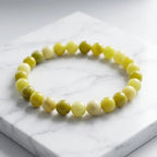 Lemon jade bracelet displayed on marble surface with glossy beads, natural stone jewelry for clean premium styling
