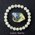 Lemon Quartz bracelet with soft pale yellow beads surrounding a raw golden iridescent quartz crystal on dark background